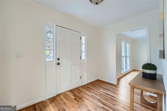 foyer featuring light hardwood / wood-style floors and crown molding