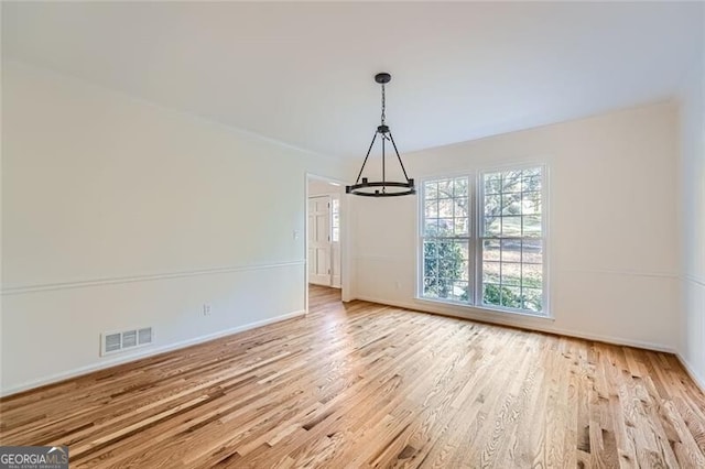 unfurnished dining area with light hardwood / wood-style floors and an inviting chandelier