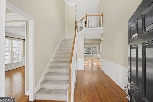 727 Pear Grove Pl, Marietta, GA 30066 - foyer entrance with wood finished floors, stairway, a wainscoted wall, a towering ceiling, and a decorative wall