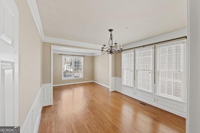 727 Pear Grove Pl, Marietta, GA 30066 - unfurnished room with a chandelier, crown molding, a wainscoted wall, light wood-type flooring, and a decorative wall