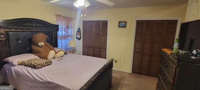 carpeted bedroom with multiple closets and ceiling fan