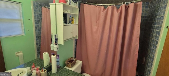 bathroom featuring a shower with curtain and toilet