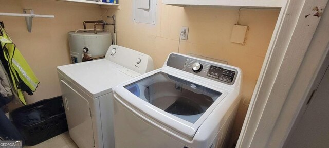 laundry room with washing machine and dryer, electric panel, and water heater