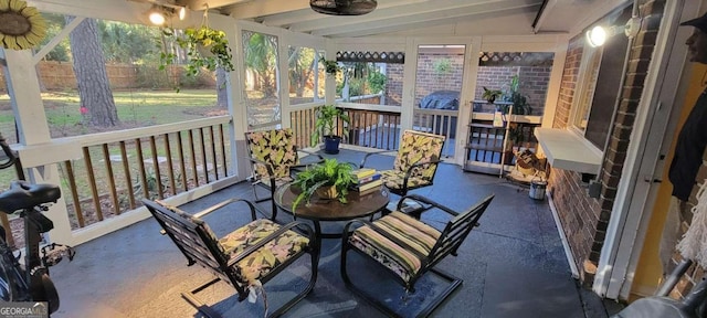 sunroom / solarium featuring lofted ceiling with beams and a wealth of natural light