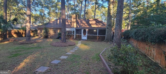 back of house with a yard and a sunroom