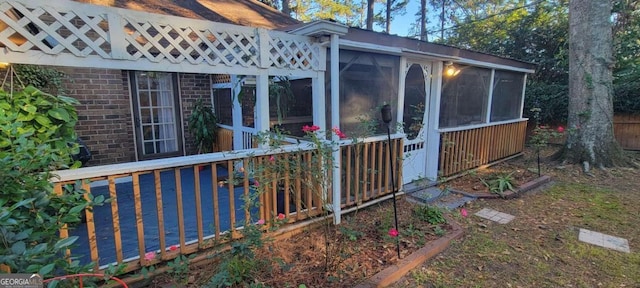 view of side of home with a sunroom and a deck