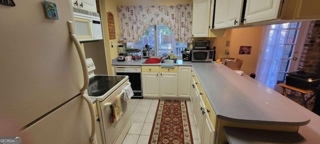 kitchen featuring light tile patterned flooring and white appliances