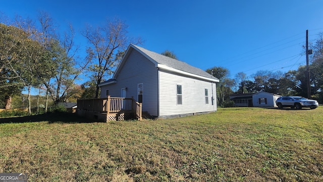 view of side of home with a wooden deck and a yard