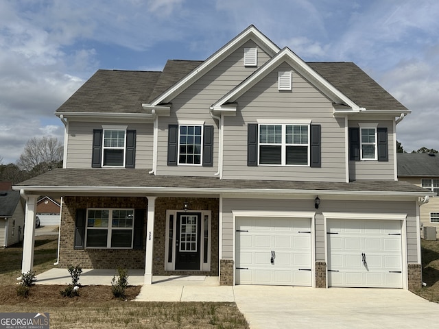 view of front of property with a porch, brick siding, driveway, and a garage