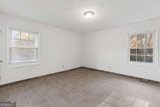 spare room with a textured ceiling