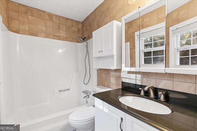 full bathroom with decorative backsplash, vanity, a textured ceiling, bathing tub / shower combination, and toilet