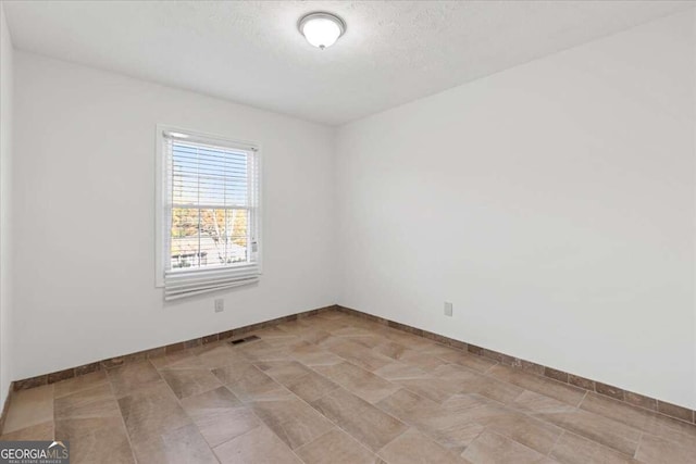 spare room with a textured ceiling