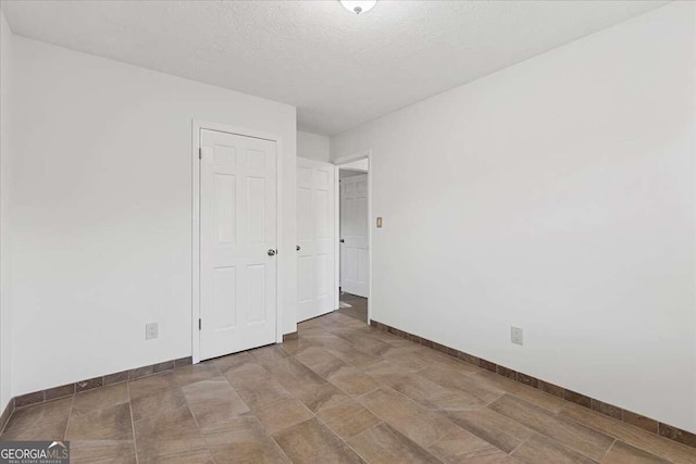 unfurnished bedroom featuring a closet and a textured ceiling