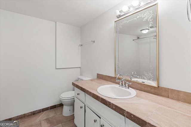 bathroom with tile patterned flooring, vanity, and toilet