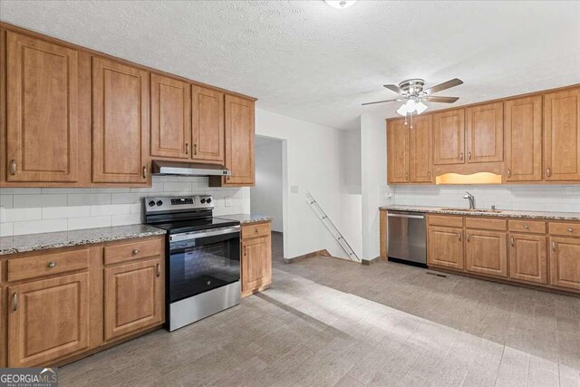 6166 Laurel Wood Trl, Flowery Branch, GA 30542 - kitchen with stainless steel appliances, under cabinet range hood, tasteful backsplash, ceiling fan, and a textured ceiling