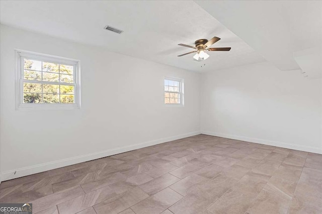 unfurnished room featuring a wealth of natural light and ceiling fan