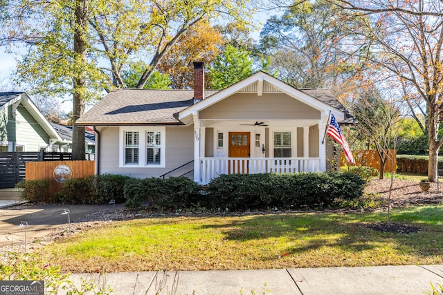 bungalow featuring covered porch, ceiling fan, and a front yard