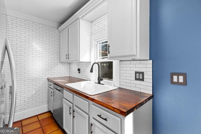 kitchen with dishwasher, sink, white cabinets, and light tile patterned floors