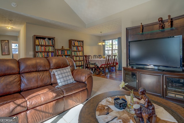 living room with a chandelier, vaulted ceiling, and wood-type flooring