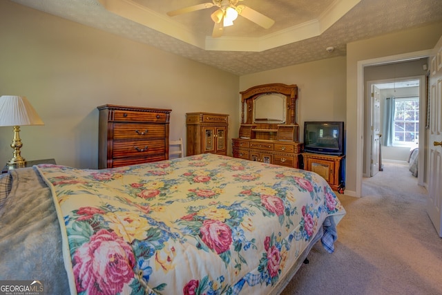 bedroom with a tray ceiling, crown molding, ceiling fan, and light colored carpet