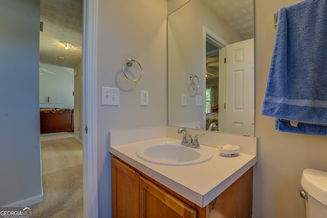 bathroom featuring vanity, a textured ceiling, and toilet