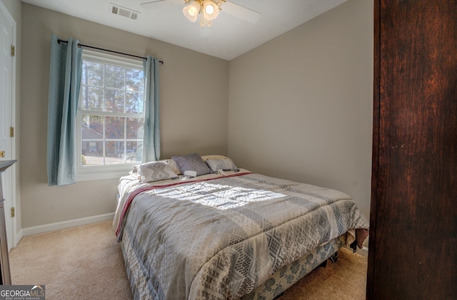 bedroom with light colored carpet, multiple windows, and ceiling fan