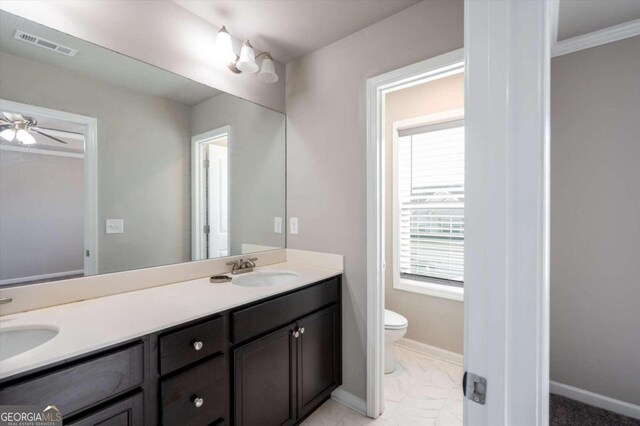 bathroom featuring vanity, toilet, ceiling fan, and crown molding