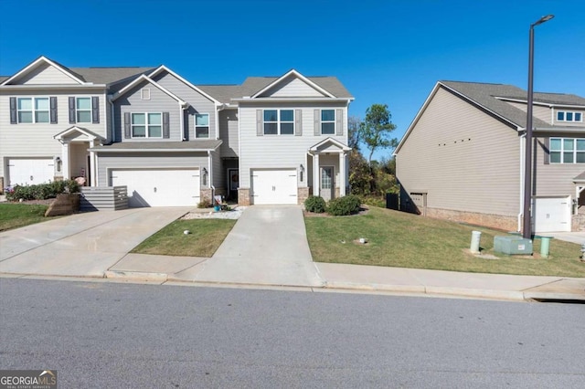 townhome / multi-family property featuring a front lawn and a garage