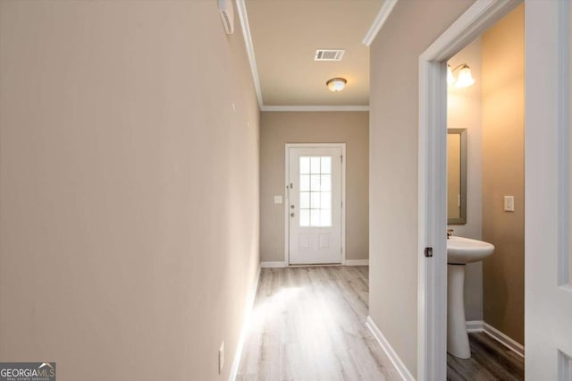 hall featuring crown molding and light hardwood / wood-style floors