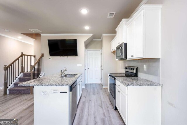 kitchen with appliances with stainless steel finishes, light stone counters, ornamental molding, light hardwood / wood-style flooring, and white cabinets