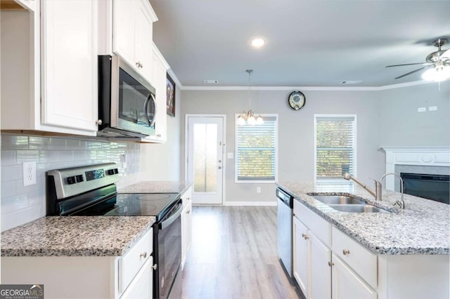 kitchen with white cabinetry, crown molding, pendant lighting, and appliances with stainless steel finishes