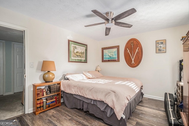 bedroom with two closets, ensuite bath, dark hardwood / wood-style floors, ceiling fan, and a textured ceiling