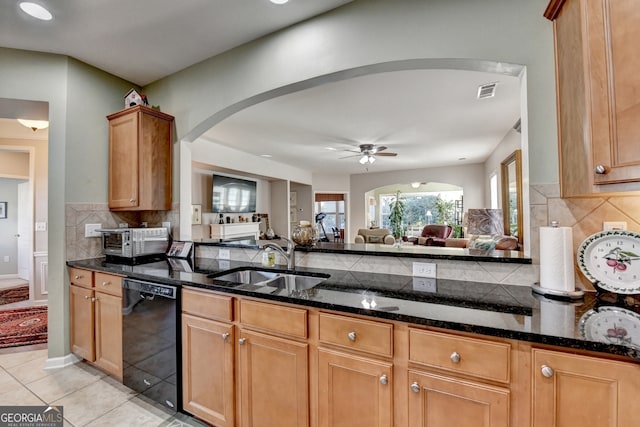 kitchen with sink, black dishwasher, light tile patterned flooring, and dark stone countertops