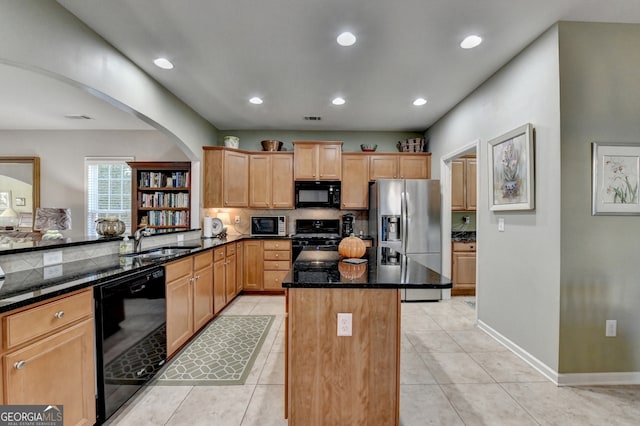 kitchen featuring sink, light tile patterned floors, dark stone counters, a kitchen island, and black appliances