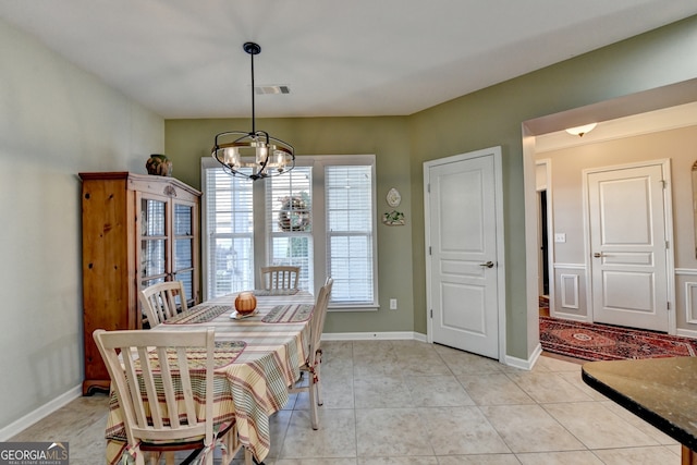 dining area with light tile patterned floors and a notable chandelier