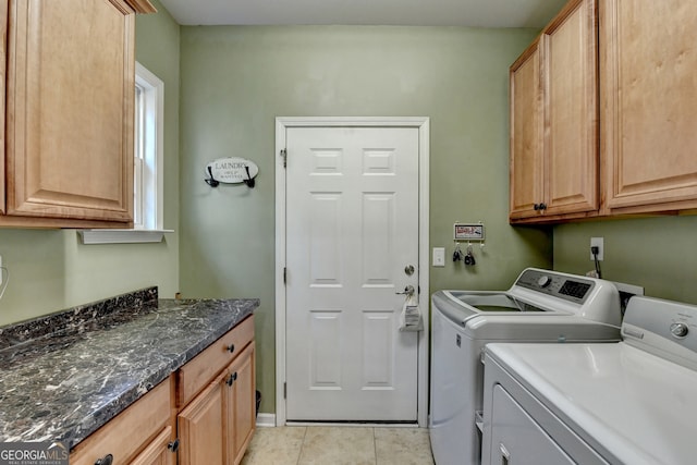 clothes washing area featuring light tile patterned flooring, cabinets, and independent washer and dryer