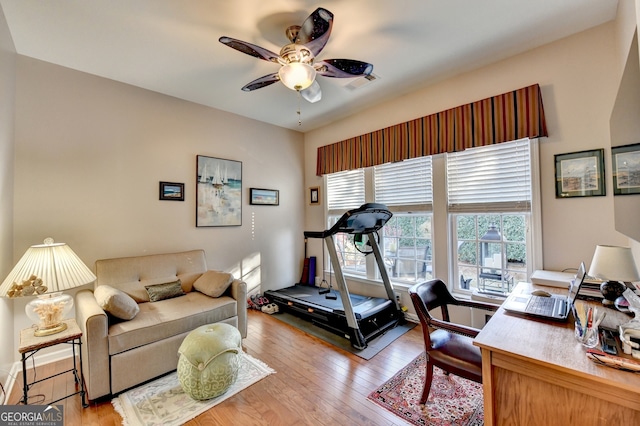 workout area with light hardwood / wood-style floors and ceiling fan