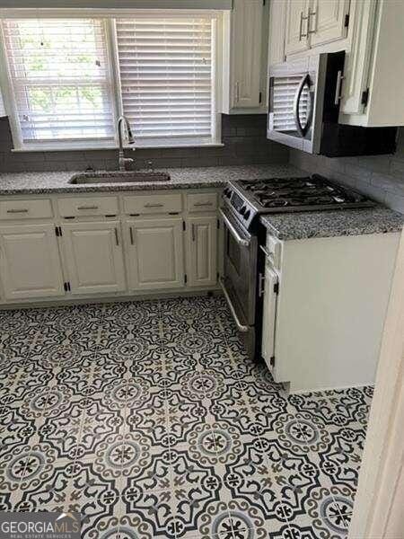 kitchen with white cabinetry, sink, and appliances with stainless steel finishes