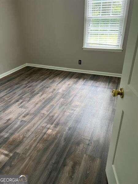 empty room with dark hardwood / wood-style flooring