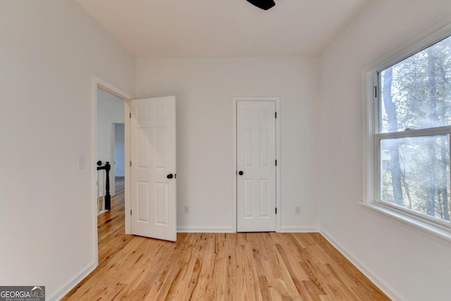 unfurnished bedroom with light hardwood / wood-style flooring and multiple windows