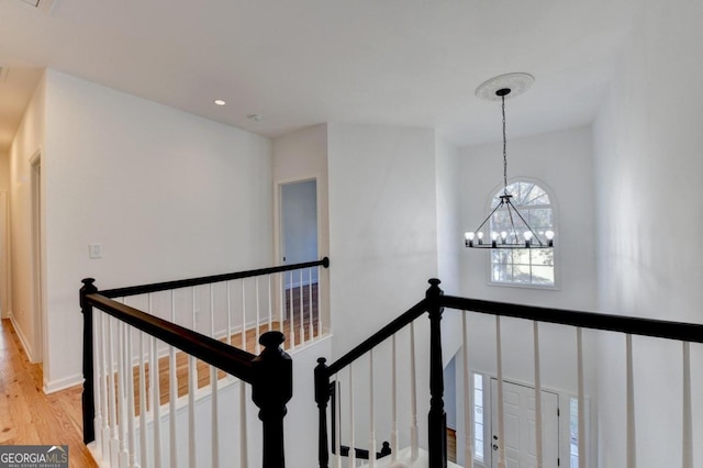 corridor featuring a chandelier and light hardwood / wood-style flooring