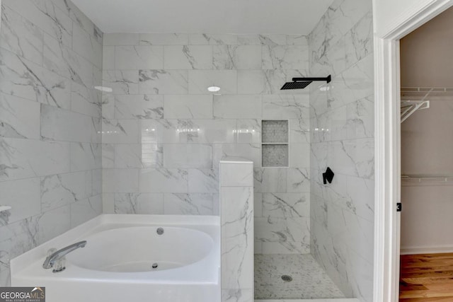 bathroom with wood-type flooring and shower with separate bathtub