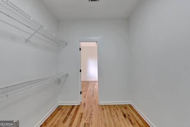 spacious closet with light hardwood / wood-style flooring