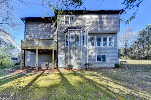 back of property with a wooden deck and a yard