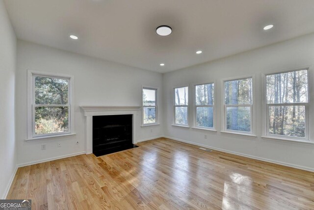 unfurnished living room with plenty of natural light and light hardwood / wood-style flooring