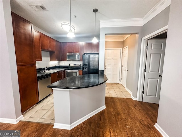 kitchen featuring light hardwood / wood-style flooring, stainless steel appliances, decorative light fixtures, and ornamental molding