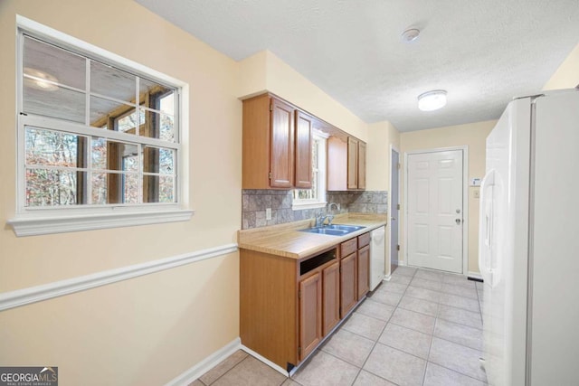 kitchen with sink, white appliances, plenty of natural light, and backsplash