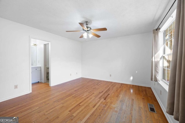 interior space featuring a textured ceiling, light wood-type flooring, and plenty of natural light