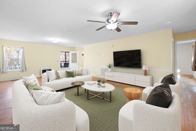 living room with hardwood / wood-style flooring and ceiling fan