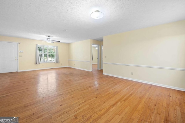 empty room with ceiling fan, a textured ceiling, and light hardwood / wood-style flooring